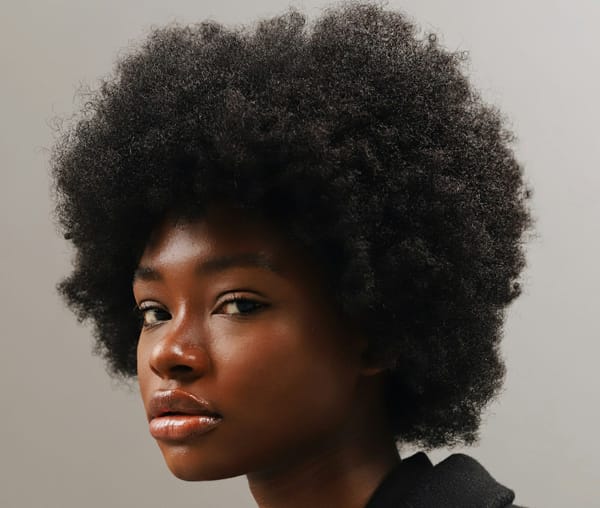 A dark skinned Black woman with a thick, curly afro.